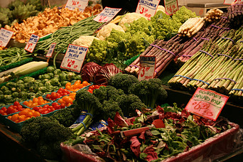 A variety of piles of fresh vegetables for sale at a farmers market. 