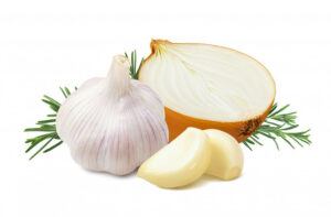 A bulb of garlic, half of an onion, and 2 peeled garlic cloves.