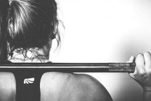 A woman holding weights on her shoulders.