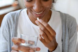 A woman taking a probiotic supplement.