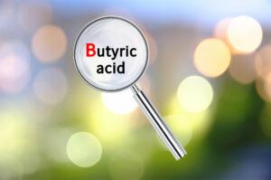 The words butyric acid with a magnifying glass over them.