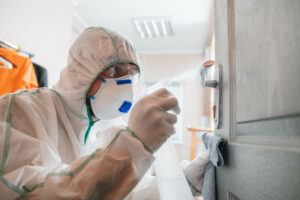 A man in protective gear doing a mold remediation. 