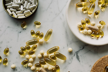 Nutritional supplment pills on a plate and a granite countertop.