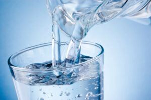 A pitcher pouring water into a glass.