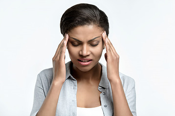 A woman with her hands on her head feeling stressed.