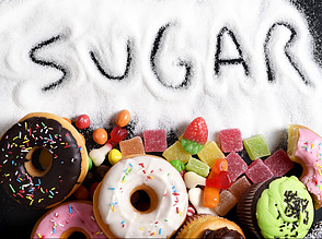 The word sugar written in white sugar with high sugar foods.