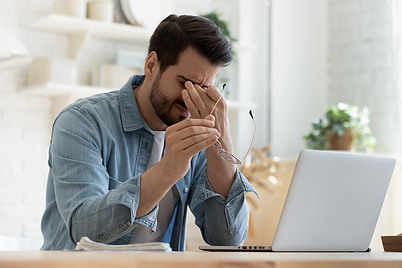 A man at his computer with fatigue.